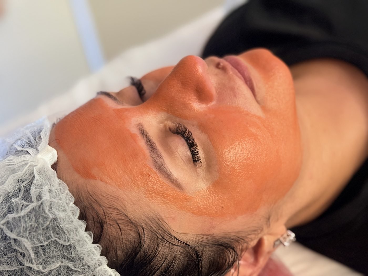 Cliente com máscara facial durante o protocolo de limpeza de pele